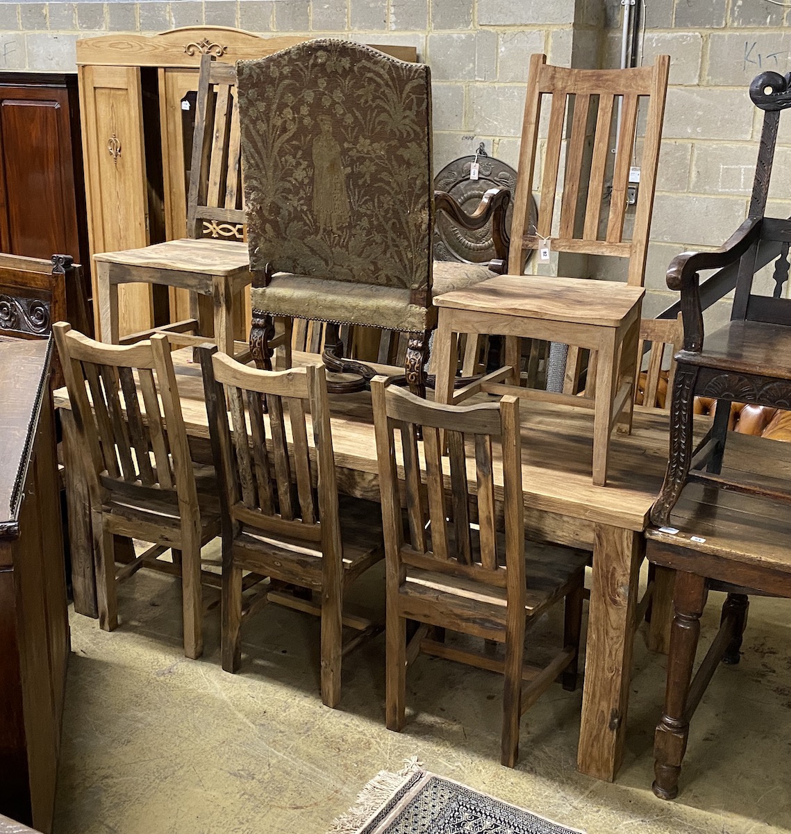 A rectangular hardwood dining table, length 200cm, depth 90cm, height 80cm and eight chairs, teak from reclaimed boat timbers